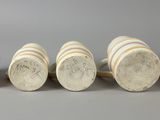 six wooden knobs are lined up in a row on a gray surface