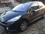 a picture of a small black car parked in the grass
