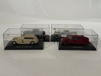 three model cars in display cases on a white surface
