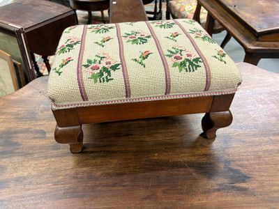 un petit tabouret posé sur une table en bois dans une pièce
