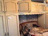 un lit dans une chambre où se trouve un lustre, avec un autre lustre au-dessus