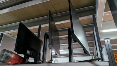 three televisions that are on a shelf in a room