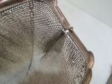 a metal strainer that is sitting on a counter
