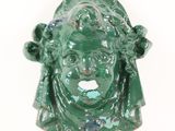 a green figurine of a woman with a hat on