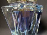a clear glass bottle with a gold lid on a table
