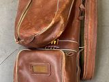 a brown bag with golf clubs in it on the floor
