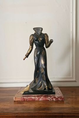 une statue représentant une femme debout sur un socle en marbre