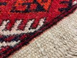close up of a red and black oriental rug with fringes