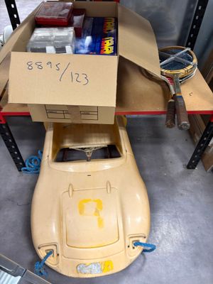 une boîte en carton posée sur une petite voiture dans un garage
