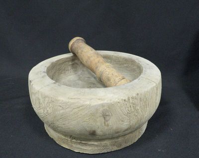 a stone mortar and a wooden stick in it