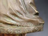 a bronze statue of a woman with a veil on her head