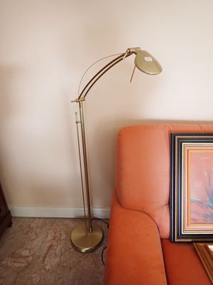 un canapé orange sur lequel est posé un tableau, à côté d'une lampe