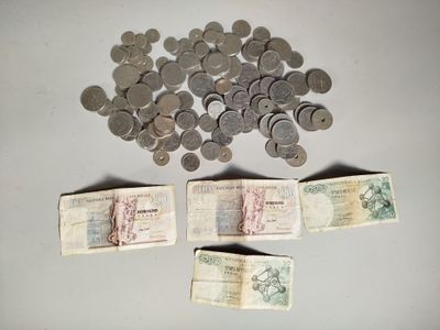 une grosse somme d'argent posée sur une table, à côté d'une pile de pièces