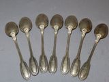 six silver spoons sitting on top of a table next to each other