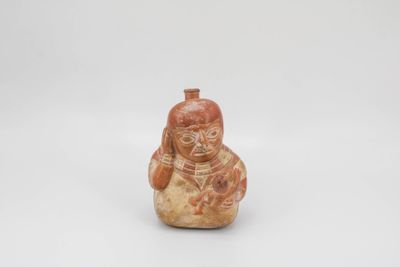 Vase représentant une maternité. La mère assise soutient sa …