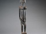 a wooden statue of a man holding a baby in his arms