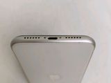 the back of a silver cell phone sitting on top of a white surface