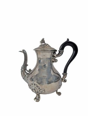an antique silver teapot with a black handle on a white background