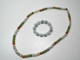 collier et bracelet composés de perles vertes et orange sur un fond blanc