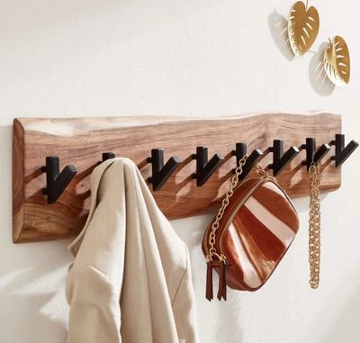 le porte-manteau est fabriqué à partir d'un morceau de bois et comporte des crochets