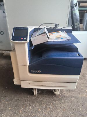 une imprimante posée par terre à côté d'une chaise