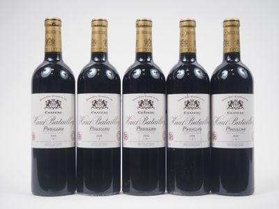 quatre bouteilles de vin sont alignées sur une surface blanche