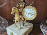 une statue représentant un homme à cheval, sur laquelle est placée une horloge
