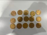 a close up of a pile of gold coins on a white surface