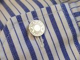 a close up of a button on a blue and white striped shirt