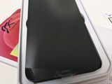 a black cell phone in a white box on a table