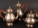 three pieces of silver tea and coffee set on a black background