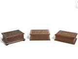 three small wooden boxes sitting next to each other on a white surface