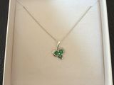une boîte blanche ornée d'un pendentif en forme de trèfle vert