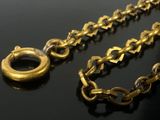 a gold chain with a ring on it on a black surface