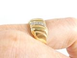 a person holding a gold ring with diamonds on it