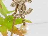 a picture of a pearl and diamond brooch on a branch