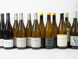 plusieurs bouteilles de vin sont alignées sur une surface blanche