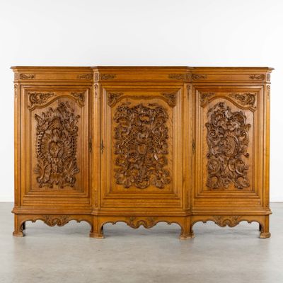 une armoire en bois ornée de sculptures et de moulures sur les portes