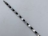 a close up of a black and white bracelet on a white surface