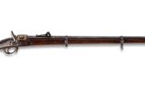 un vieux fusil avec un canon en bois et des garnitures métalliques