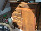 a dresser in the corner of a room with boxes on top of it