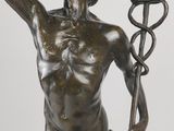 bronze statue of a man holding a staff with a snake on it