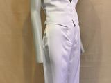 Le mannequin porte une robe blanche avec un décolleté en V plongeant.
