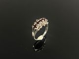 une bague en or blanc sertie de grenats et de diamants sur un fond noir