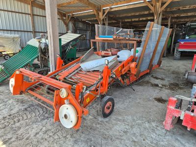 un tracteur garé dans une grange avec d'autres machines agricoles