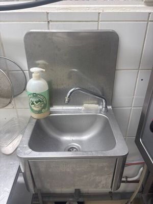 a sink with a bottle of cleaner next to it