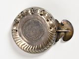 a silver plate with a metal handle on a white surface
