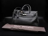 a black leather handbag and an umbrella on a black background