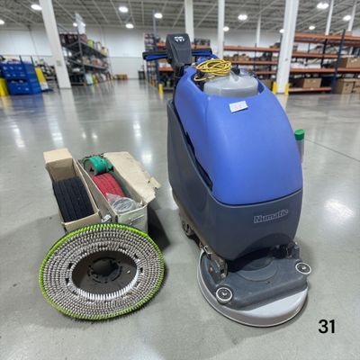 a blue machine sitting on top of a floor in a warehouse
