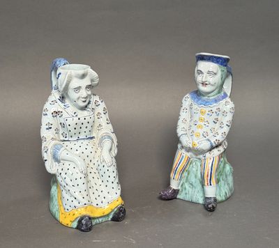 pair of ceramic figurines of a man and a woman sitting next to each other
